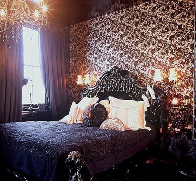 a refined Gothic bedroom with printed wallpaper, exquisite furniture, a crystal chandelier and wall sconces for a vintage feel
