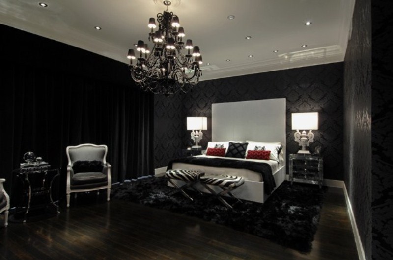 a classic Gothic bedroom with black printed wallpaper, a white bed, mirror nightstands, elegant furniture and an oversized and refined chandelier