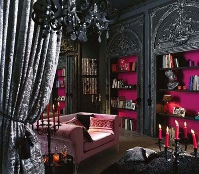 a glam black and pink Gothic bedroom with black walls, built in shelves with fuchsia backing, refiend furniture and a crystal chandelier just wows