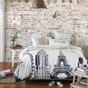 a modern bedroom with a shabby chic whitewashed brick wall, modern furniture and a pendant metal lamp, a woven rug