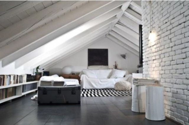 a Nordic attic room with a whitewashed brick wall, a hearth, modern furniture, a chest and open shelves with books