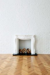 such a space with whitewashed brick walls and a refined non-working fireplace is a chic space with a Parisian feel