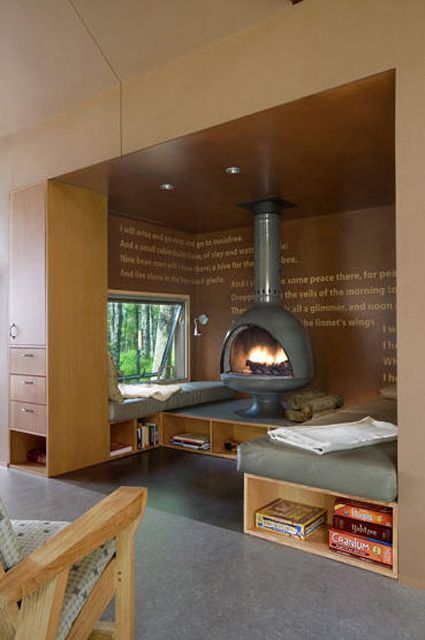 a special fireplace nook with daybeds with storage, a hearth and a window is aimed at enjoying coziness here