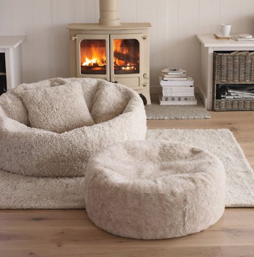 a modern neutral nook with a beige hearth, a coupel of large floor cushions and some books for curling here