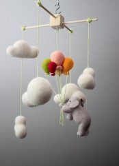 a super fun and cool nursery mobile with felt clouds and a felt elephant plus balloons is a cool idea for a gender-neutral nursery