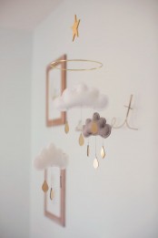 a delicate nursery mobile with grey and white clouds of felt and gold raindrops will easily fit any space