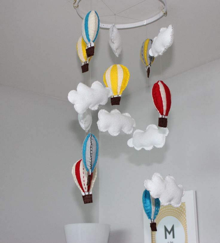an amazing nursery mobile with colorful hot air balloons and clouds is fun and cool idea that will work for any nursery in any style
