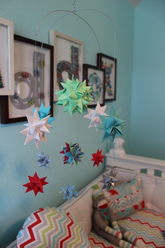a bright nursery mobile with colorful 3D paper stars can be easily DIYed by you yourself and can make your kid's room bolder