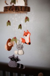 a fun and cool mobile with little felt animals – a fox, a raccoon, a bunny and a bird plus some leaves is a cool idea for a forest-themed nursery