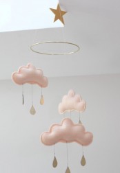 a delicate and dreamy nursery mobile with blush clouds and gold raindrops plus a gold star is amazing for any kids’ space