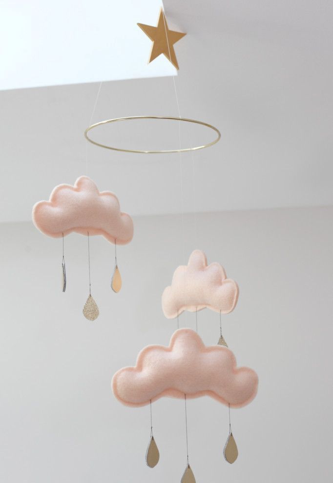 a delicate and dreamy nursery mobile with blush clouds and gold raindrops plus a gold star is amazing for any kids' space
