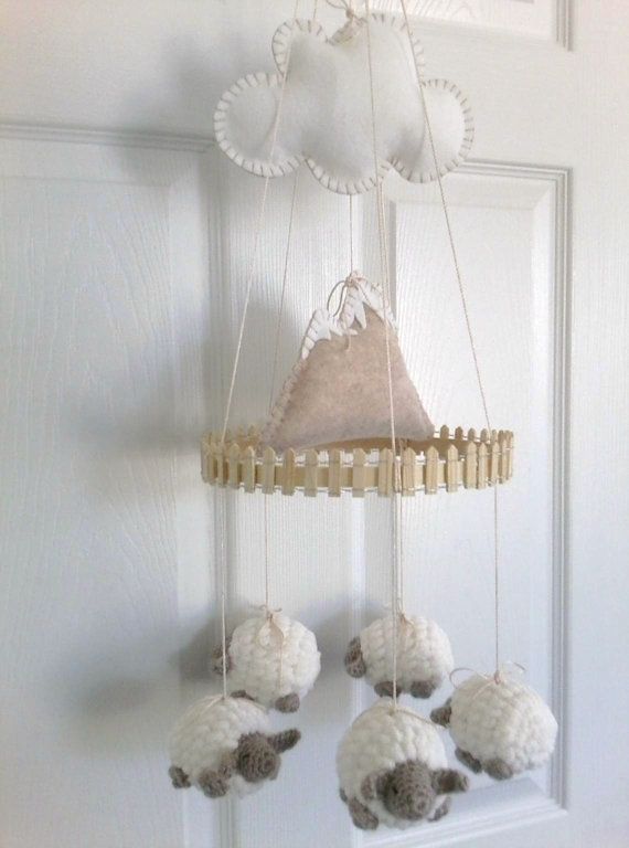a creative tiered mobile with a cloud, a mountain and some neutral crochet sheep is a cool and unusual solution for a neutral nursery