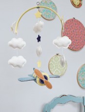 a beautiful mobile with felt clouds and stars plus an airplane is a catchy and bold solution for an airplane-inspired nursery