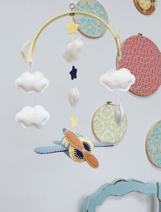 a beautiful mobile with felt clouds and stars plus an airplane is a catchy and bold solution for an airplane-inspired nursery