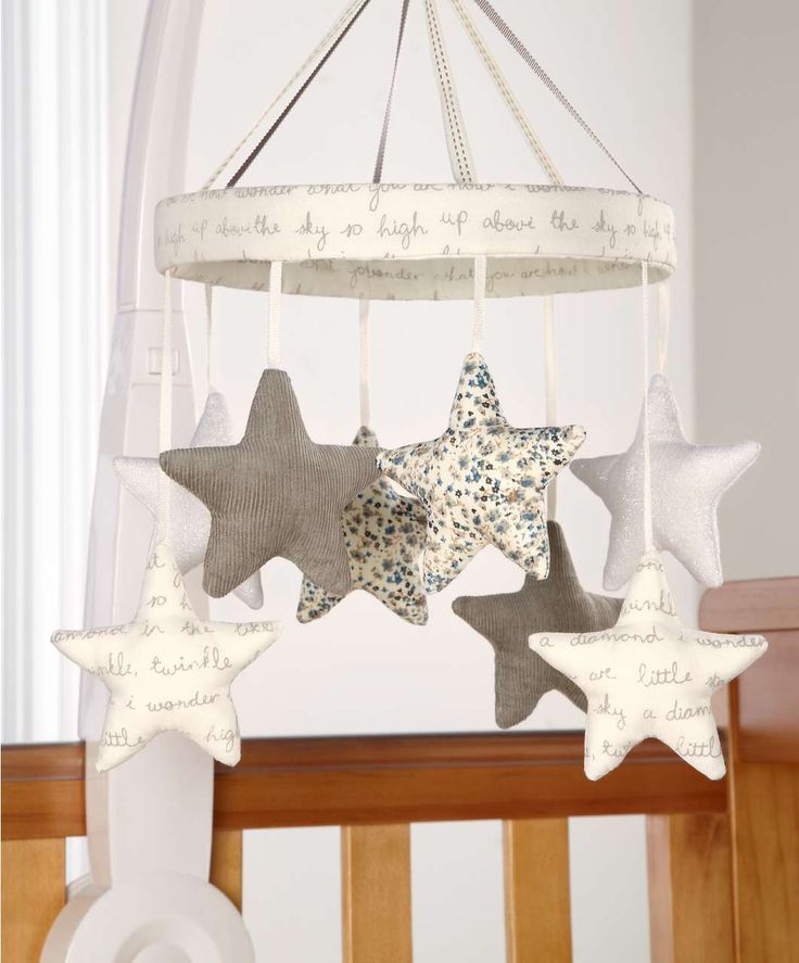 a neutral nursery mobile with printed, neutral and quote fabric stars hanging down is a chic and refined solution