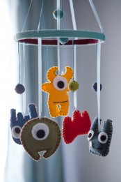 a colorful nursery mobile with bold felt monsters will add a touch of color and fun to the nursery