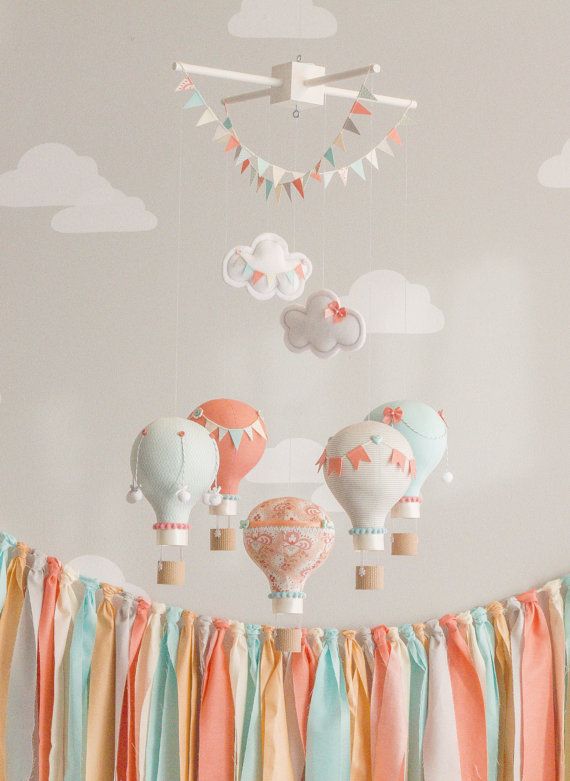 a cool muted color nursery mobile with paper hot air balloons and buntings is a very fun and cute idea for a gender neutral space