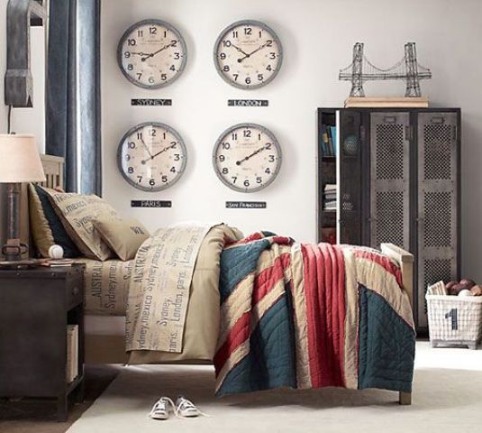 a stylish industrial bedroom with neutral walls, a bed with bright bedding, stained furniture, a metal file cabinet for storage, a series of clock