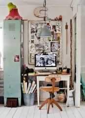 an industrial home office nook with a white desk, a small chair, a mood board, a light green storage cabinet of metal, a pendant lamp and various decor