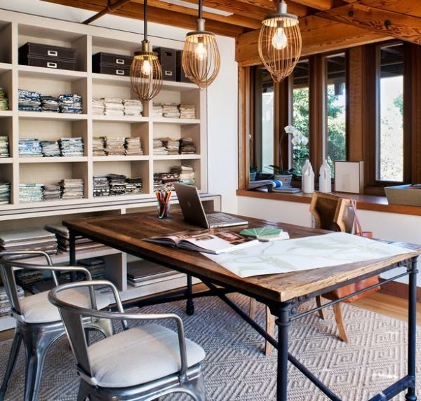 an eclectic home office with industrial touches, with wooden beams, built in shelving units, an industrial metal and wood desk and metal chairs