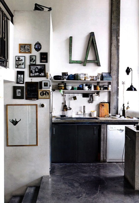 Rough surfaces and hight ceilings make this kitchen looks like it's located on some manufacturing facility.