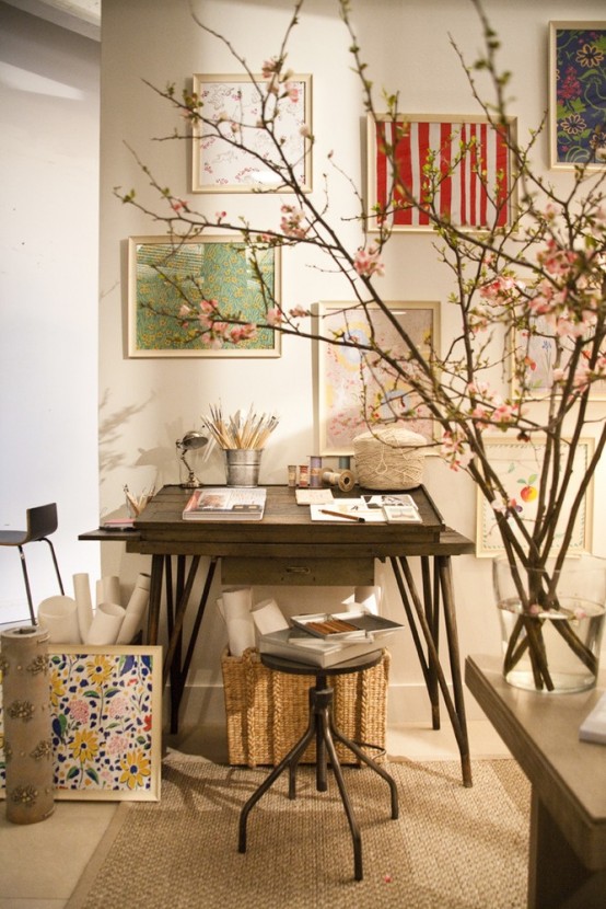 a small home artist studio with a sleek desk and a stool, a basket for storage and a gallery wall of artwork