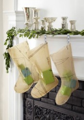 an elegant Christmas mantel with a greenery garland, metallic candleholders, creative stockings with some gifts inside