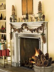 a woodland Christmas mantel with oversized pinecones, branches and pinecone garlands on the mantel and an urn with them by the fireplace