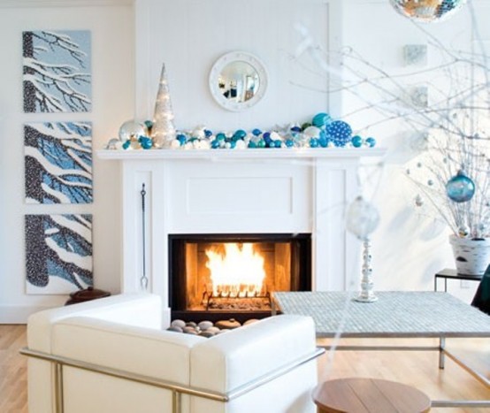 a beautiful frozen Christmas mantel in icy blues and white, with lots of ornaments of various sizes and a faux Christmas tree