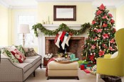 a lush evergreen garland with ribbons, stockings with red and green touches are all you need for a chic and cool mantel at Christmas