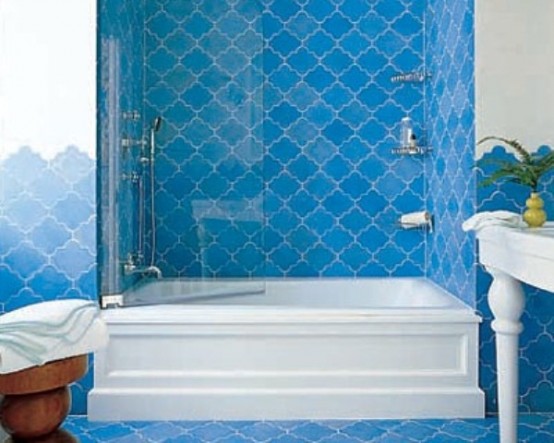 a bright blue bathroom with Moroccan tiles and vintage-inspired furniture
