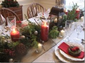 a rustic Christmas tablescape with a burlap runner, evergreens, pinecones, red candles and sparkling ornaments