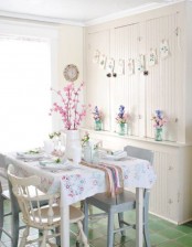 a pastel dining zone with a floral garland, pastel blooms, floral print linens on the table