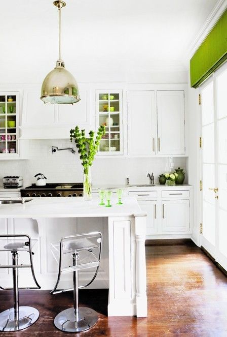 a green Roman shade, gree glasses, greenery in a vase and green mugs add color and refresh the kitchen for spring