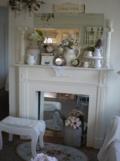 a vintage spring mantel with floral arrangements, jugs, clocks, pillars and a mirror