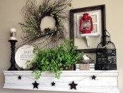 a blooming and greenery wreath over the mantel, potted greenery, a fake bird and a bird cage