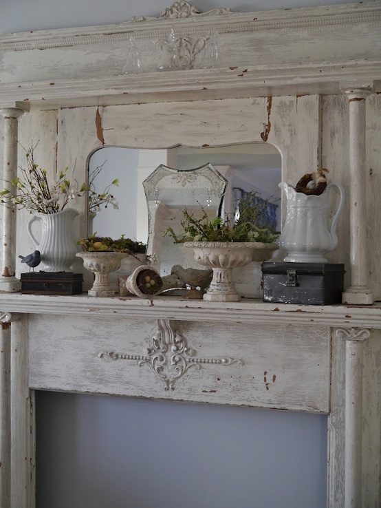 a vintage spring mantel with bowls with moss and eggs, blooming branches in a jug