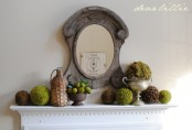a vintage-inspired spring mantel with moss balls, fake fruit arrangement and topiaries