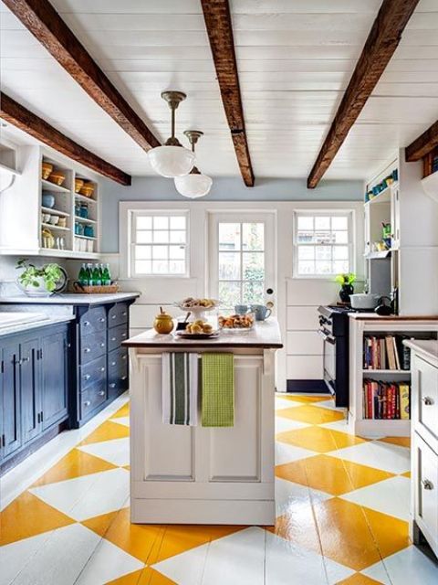 a bright eclectic kitchen with dark lower cabinetry and white upper cabinets, a bright geometric floor, dark wooden beams on the ceiling for a traditional feel