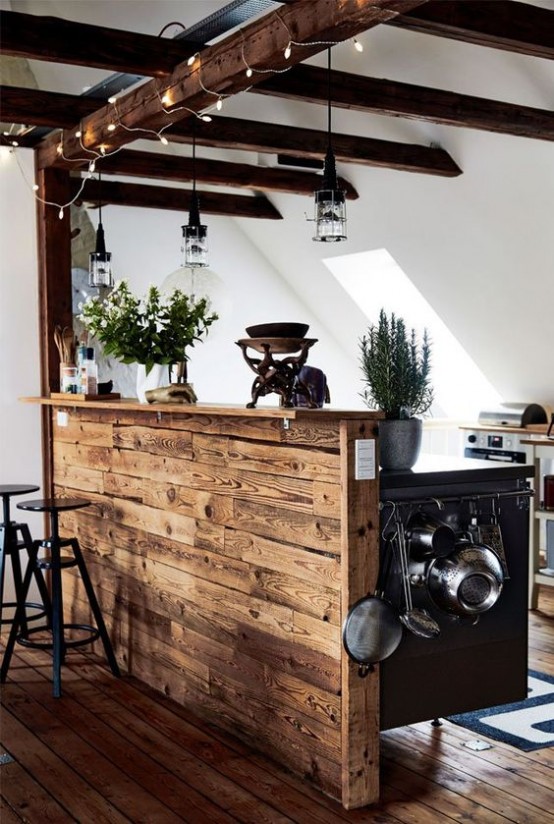 a contemporary neutral kitchen with white cabinets, a wooden kitchen island, wooden beams with lamps and lights that match and add coziness to the space