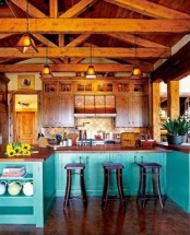 a bright kitchen with wooden upper cabinets and turquoise lower ones, rich-toned wooden beams with pendant lamps for a more catchy and vintage look