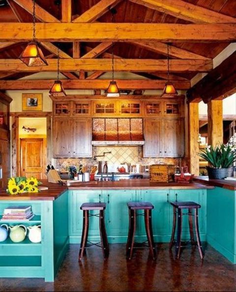 a bright kitchen with wooden upper cabinets and turquoise lower ones, rich-toned wooden beams with pendant lamps for a more catchy and vintage look