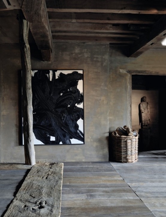 a wabi-sabi living room covered with rough wood, planks, beams, artworks and a basket for storage