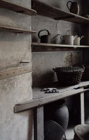 a wabi-sabi pantry in wood and stone, with baskets and buckets, a large vase for storage