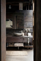 a wabi-sabi bathroom with a rough wooden wall, a rough wooden vanity and a stone sink