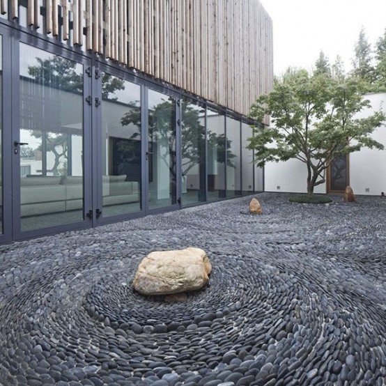 un jardín de rocas japonés compuesto de guijarros y rocas, con un solo árbol acentuado