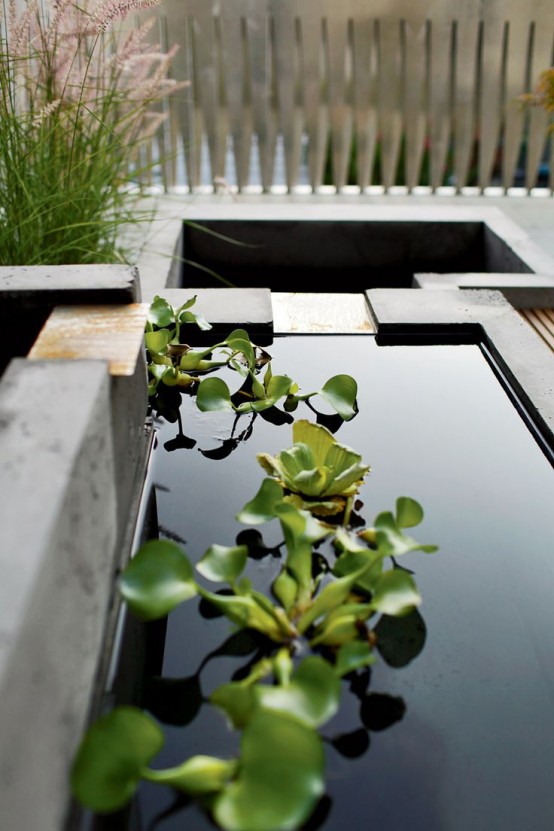 un jardín japonés minimalista con césped y un par de estanques con vegetación flotante