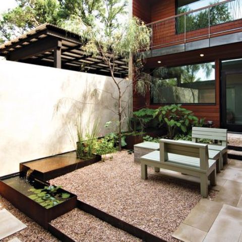 un patio trasero contemporáneo con un toque japonés y una serie de estanques con vegetación, hojas y un árbol junto a ellos