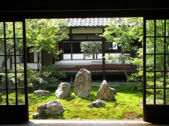 un jardín japonés clásico con césped, rocas grandes y árboles bajos de estilo japonés