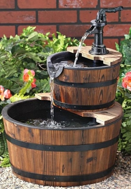 a small tiered rustic fountain composed of wooden buckets and with a black faucet is a creative idea for a rustic space